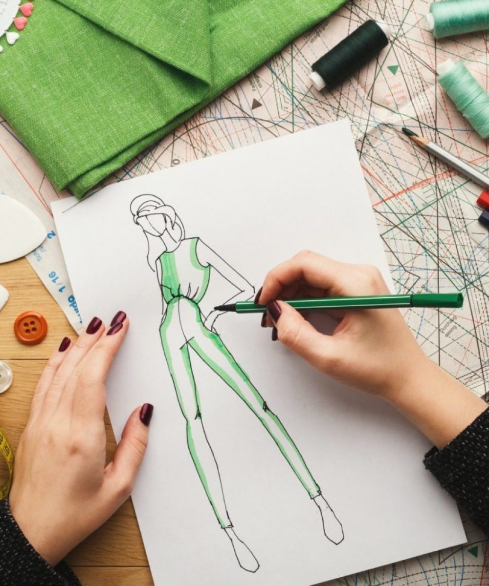 top-view-on-woman-designer-drawing-clothes-sketches-e1649869837824.jpg